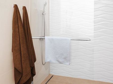 Alleinstehende Duschwand aus Glas in einer modernen Fliesenkombination Alleinstehende Duschwand aus Glas in einer modernen Fliesenkombination