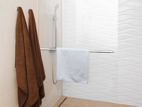 Alleinstehende Duschwand aus Glas in einer modernen Fliesenkombination