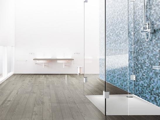 Duschtrennwand aus Glas in frei Teilen vor blauen Mosaikfliesen Duschtrennwand aus Glas in frei Teilen vor blauen Mosaikfliesen